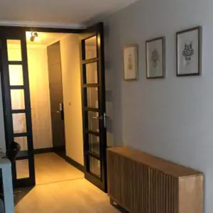 Un pasillo con cuadros en la pared y una puerta que da a otra habitación