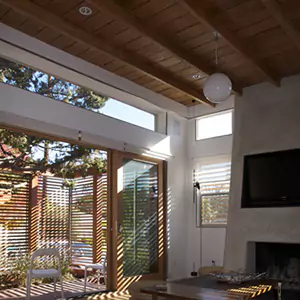 Un salón con techo de madera y grandes ventanales